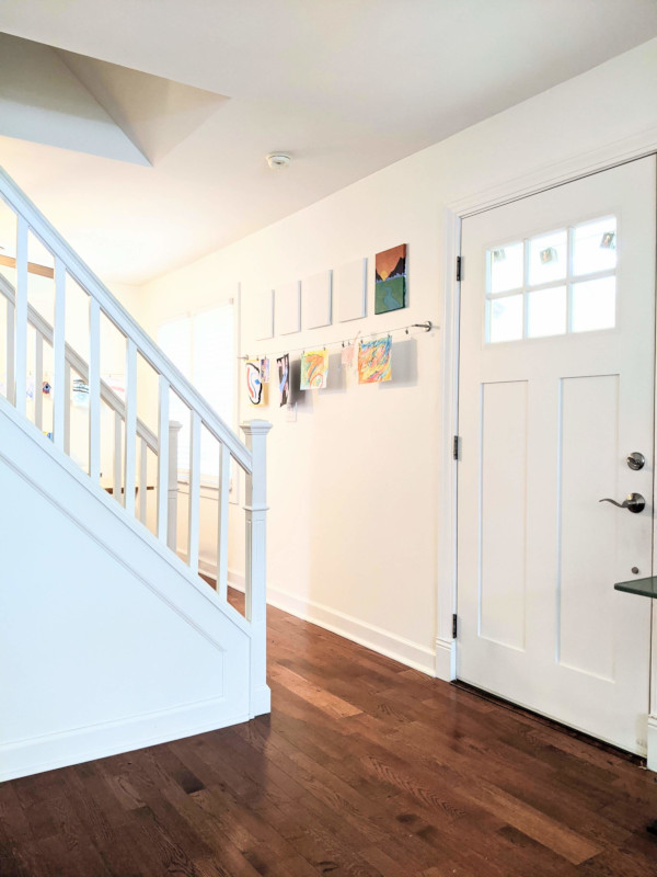 White door, walls and staircase help showcase woodworking details and allow the hardwood floor to stand out.